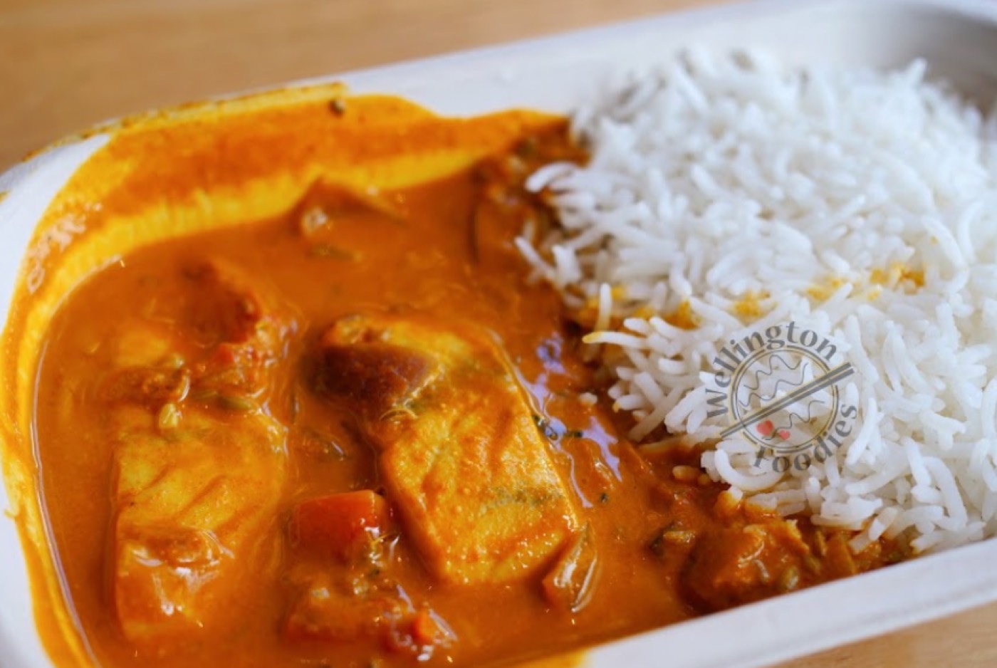 Fish curry with basmati rice in a takeaway container