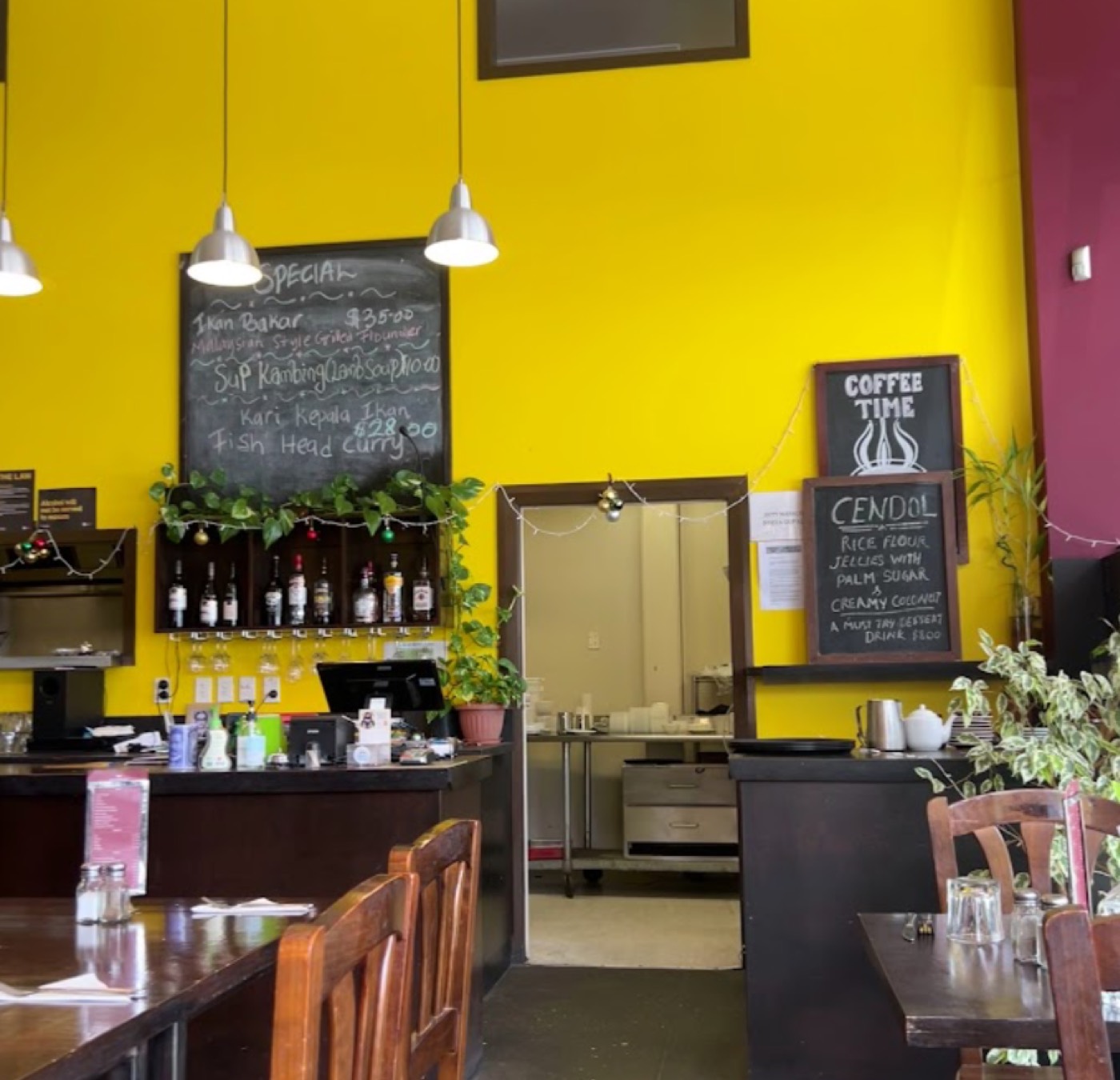 Inside the restaurant — specials blackboard and counter against a yellow wall
